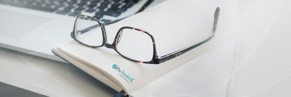 Glasses on book with PreAnalytiX news